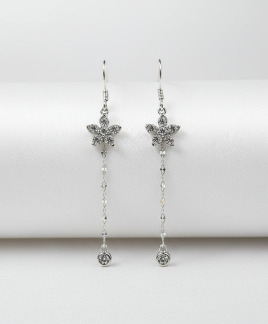 Silver flower earrings with chain details on a white background