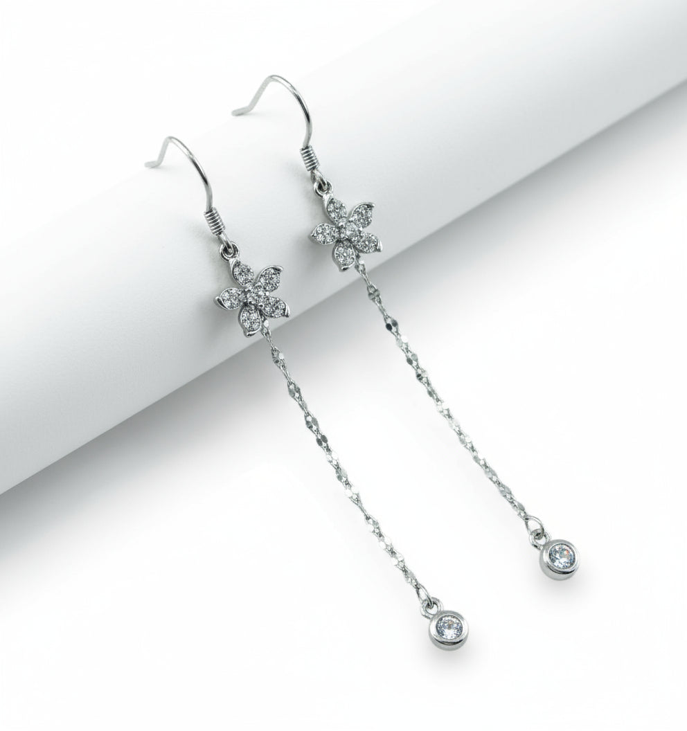 Silver earrings with floral designs on a white background