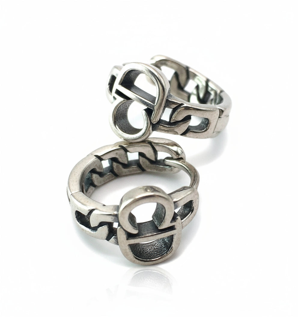 Silver ring with intricate design on a white background