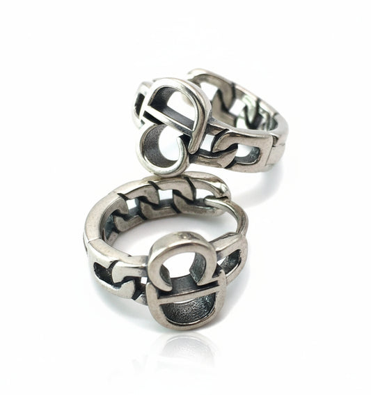 Silver ring with intricate design on a white background