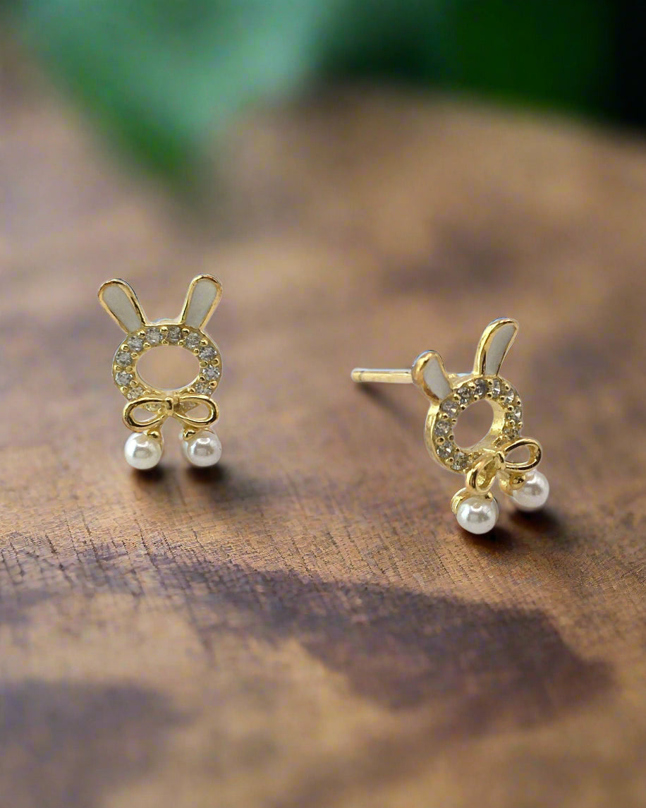 Gold bunny-shaped earrings with pearl details on a white background