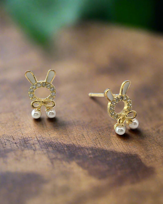 Gold bunny-shaped earrings with pearl details on a white background