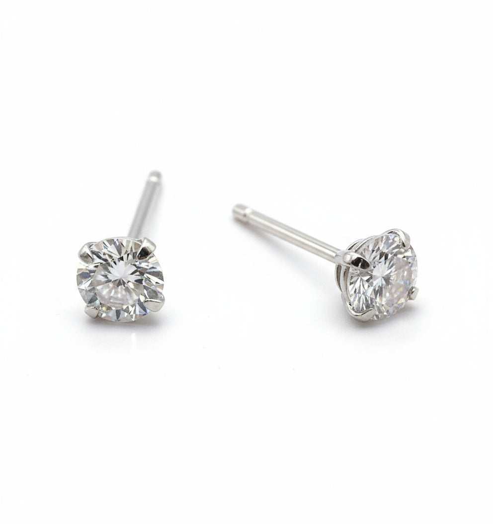 Pair of silver stud earrings with clear gemstones on a white background