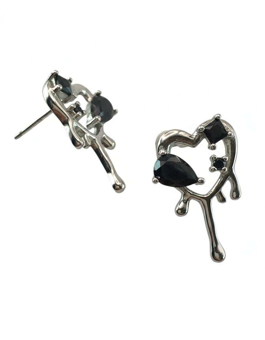 Heart-shaped earrings with black stones on a white background