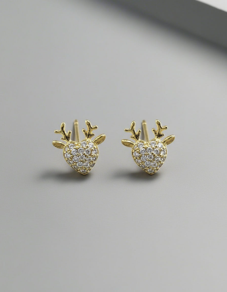 Gold earrings with heart and antler design on a white background