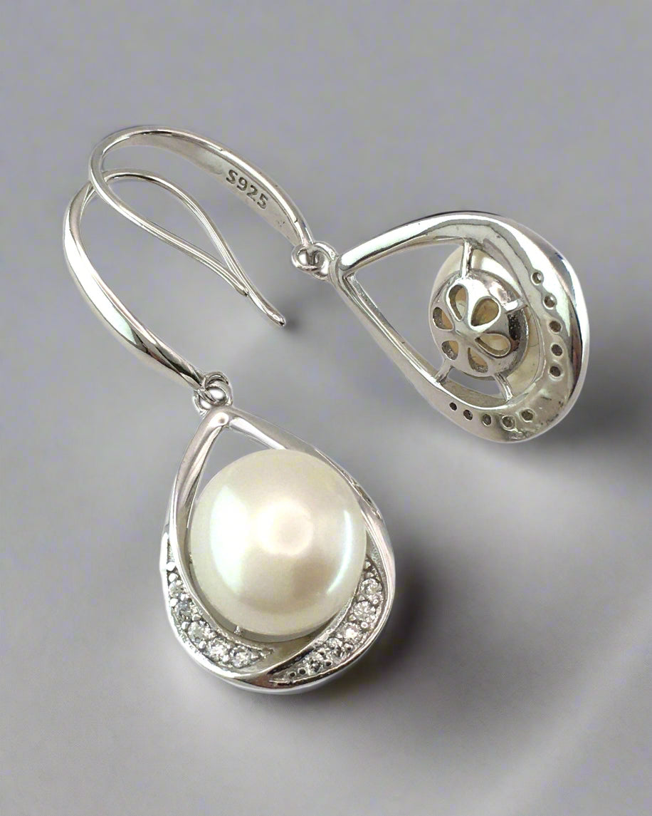 Pearl earring with silver teardrop design on a white background