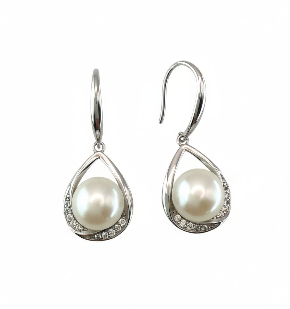 Pearl earrings with silver teardrop designs on a white background
