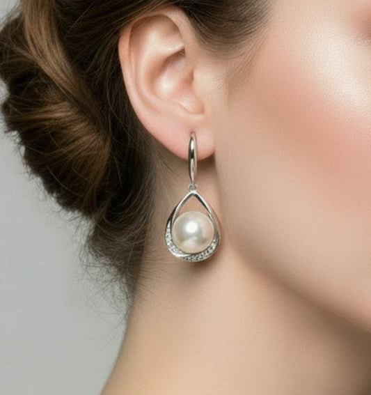 Pearl earrings with silver teardrop designs on a white background