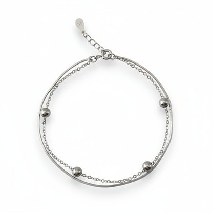Silver bracelet with small beads on a white background