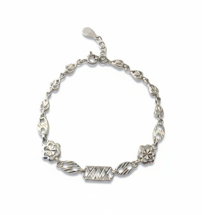 Silver bracelet with floral and geometric designs on a white background