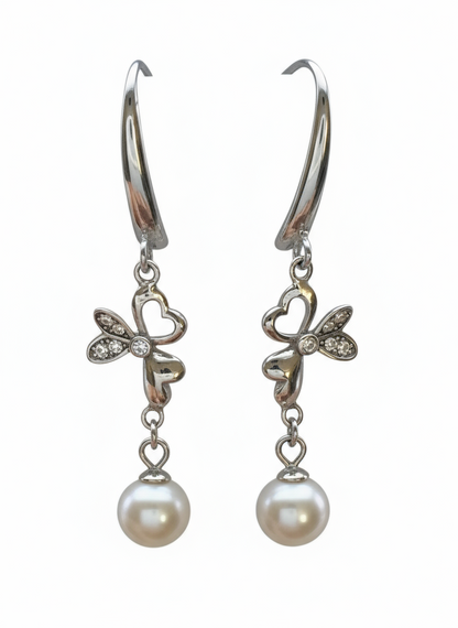 Pair of silver earrings with butterfly designs and pearl drops on a white background