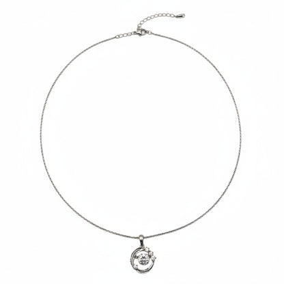 Silver necklace with a small round pendant on a white background