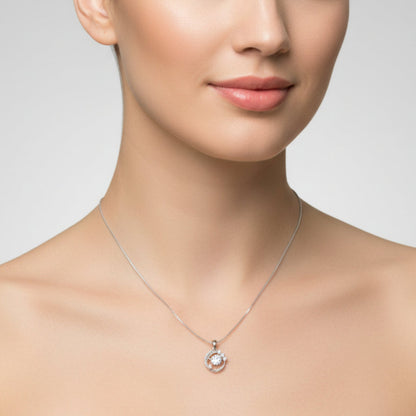 Silver necklace with a small round pendant on a white background
