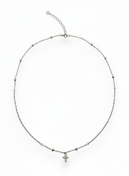 Silver necklace with a small cross pendant on a white background