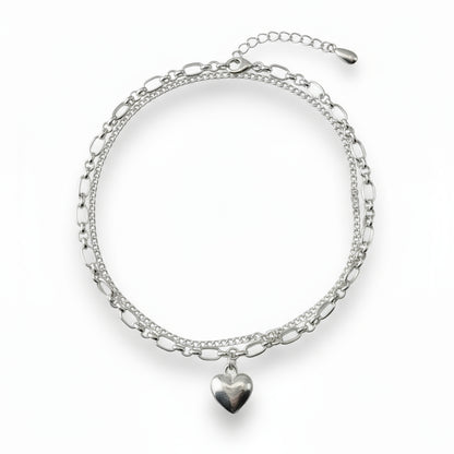 Silver bracelet with heart charm on a white background