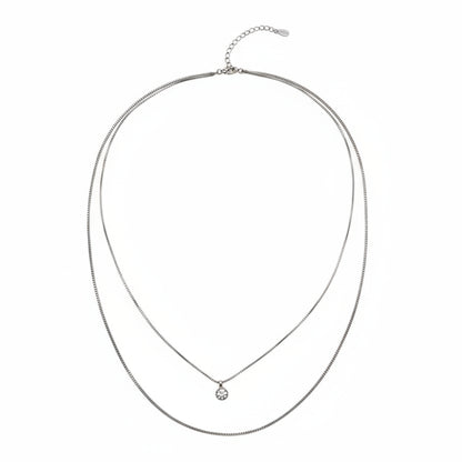 Silver necklace with a small pendant on a white background