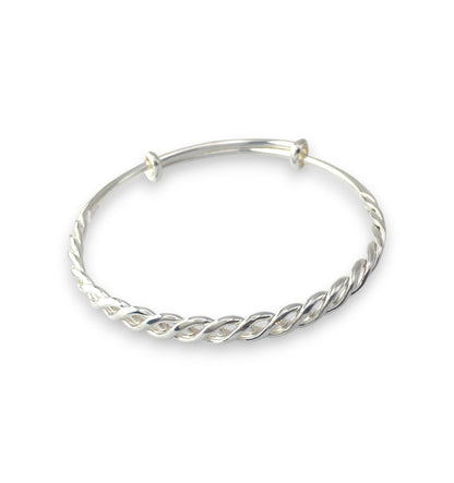 Silver bangle with a twisted design on a white background