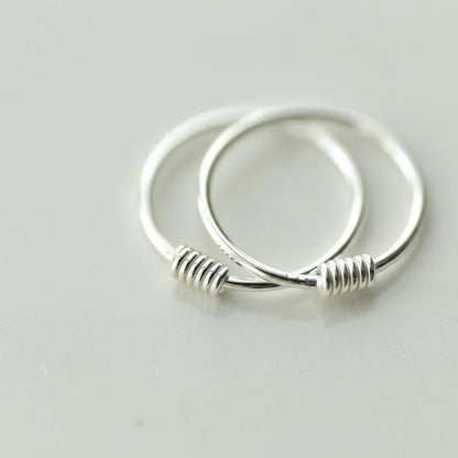 Silver hoop earrings on a light gray background