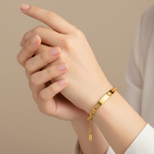 Gold chain bracelet with a diamond on a white background