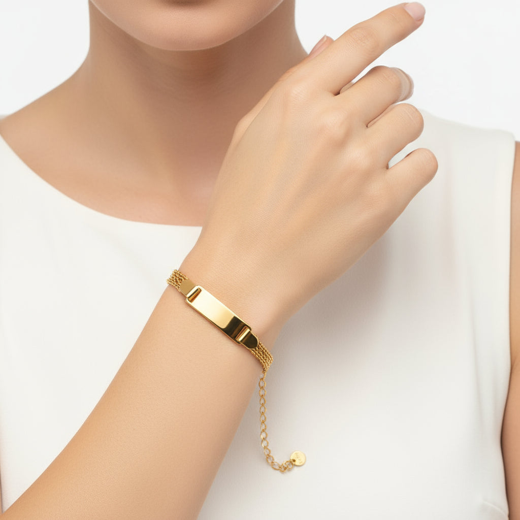 Gold bracelet with a chain design on a beige fabric background