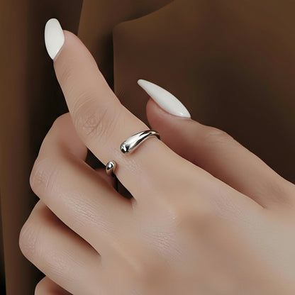 Hand wearing a silver ring with a plain background