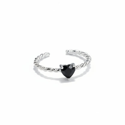 Silver ring with a black heart-shaped gemstone on a white background