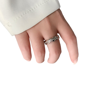 Hand wearing a ring on a book with text
