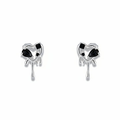 Pair of heart-shaped earrings with black gemstones on a white background