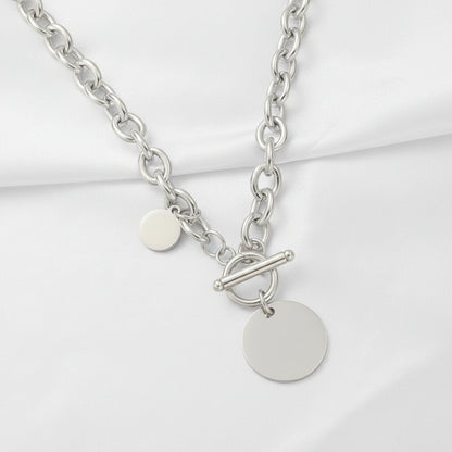 Silver chain necklace with round pendants on a pink satin background