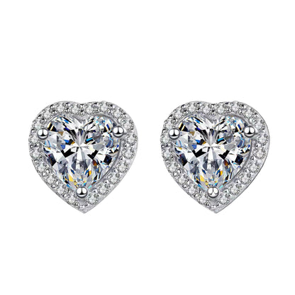 Heart-shaped earrings with clear gemstones on a black background