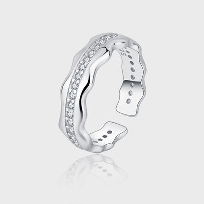 Silver ring with diamond accents on a light gray background