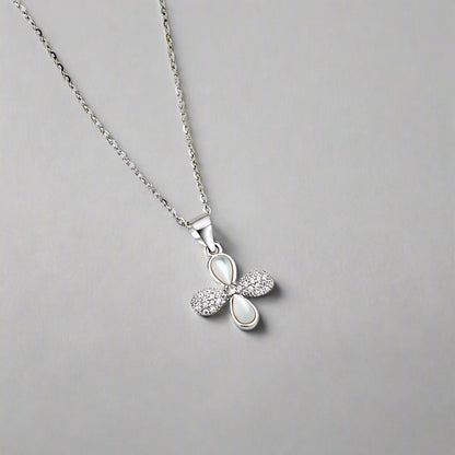 Silver necklace with a bow-shaped pendant on a white background
