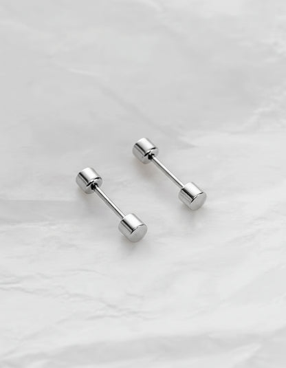Pair of silver barbell-shaped earrings on a light gray background