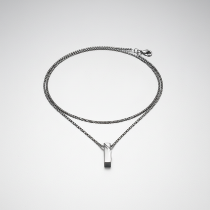Silver chain necklace with a rectangular pendant on a white background