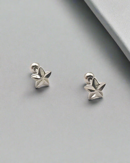 Pair of silver star-shaped earrings on a white background