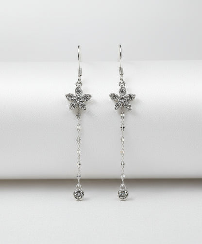 Silver flower earrings with chain details on a white background
