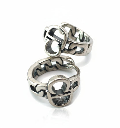 Silver ring with intricate design on a white background