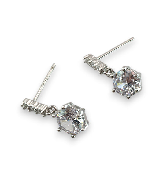 Silver earrings with clear gemstones on a white background