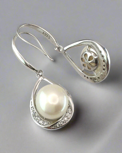 Pearl earring with silver teardrop design on a white background